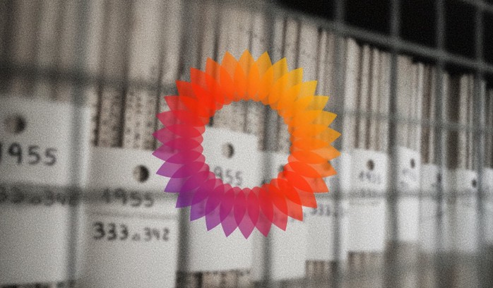 The MediaWiki logo on a blurred photo of documents in grayscale.