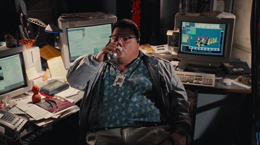 Dennis Nedry in Jurassic Park vibing, drinking a soda, in front of computers.
